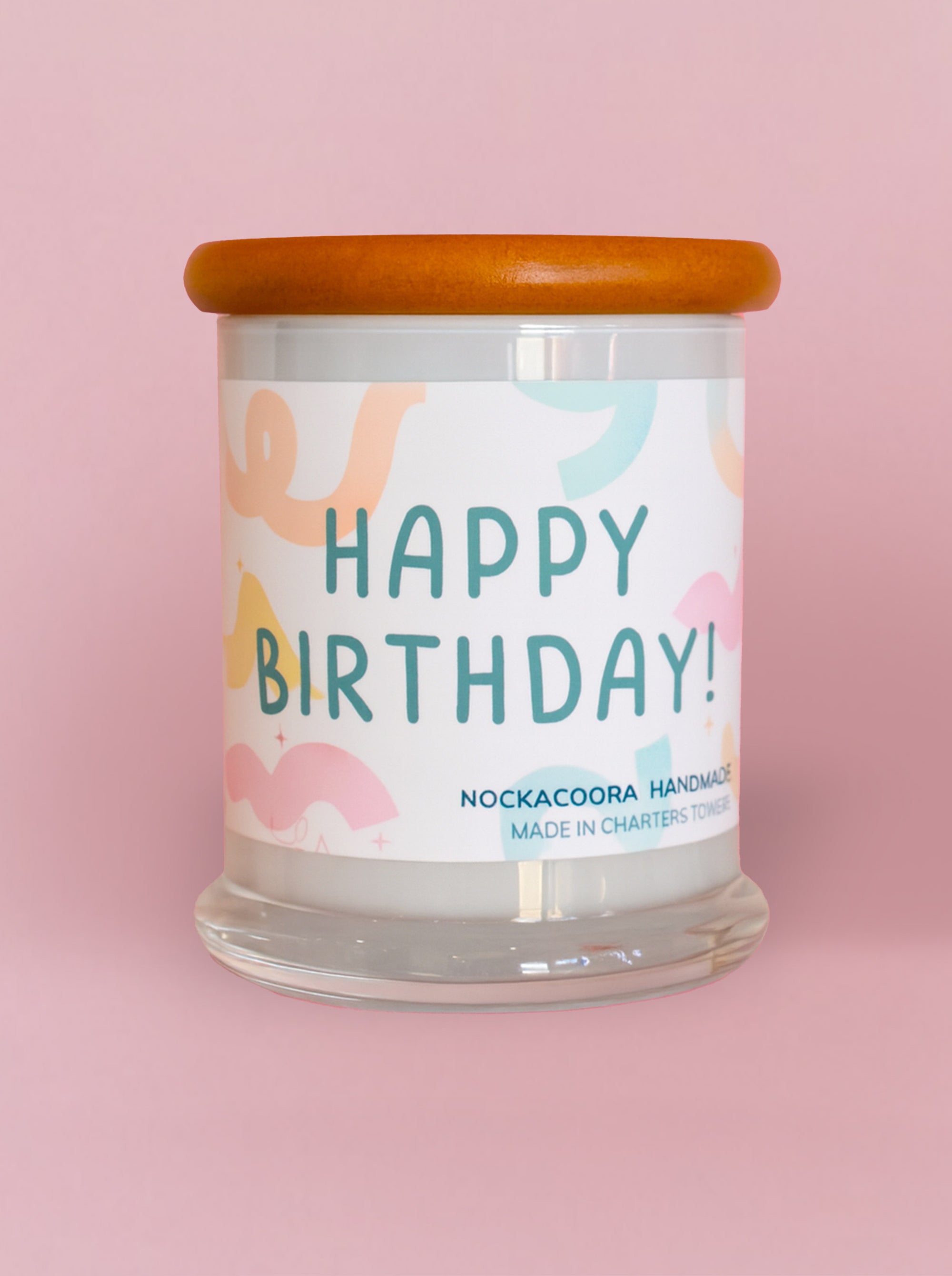 Candle with a 'Happy Birthday!' label on a pink background